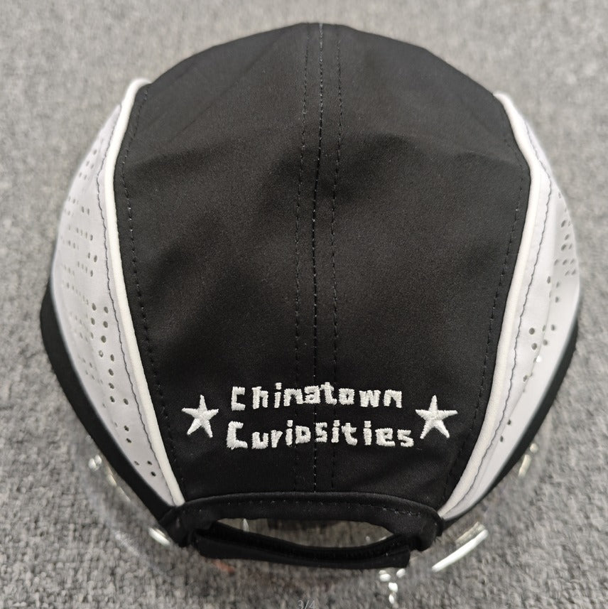 Black and white cap with 'Chinatown Curiosities' text on a gray background