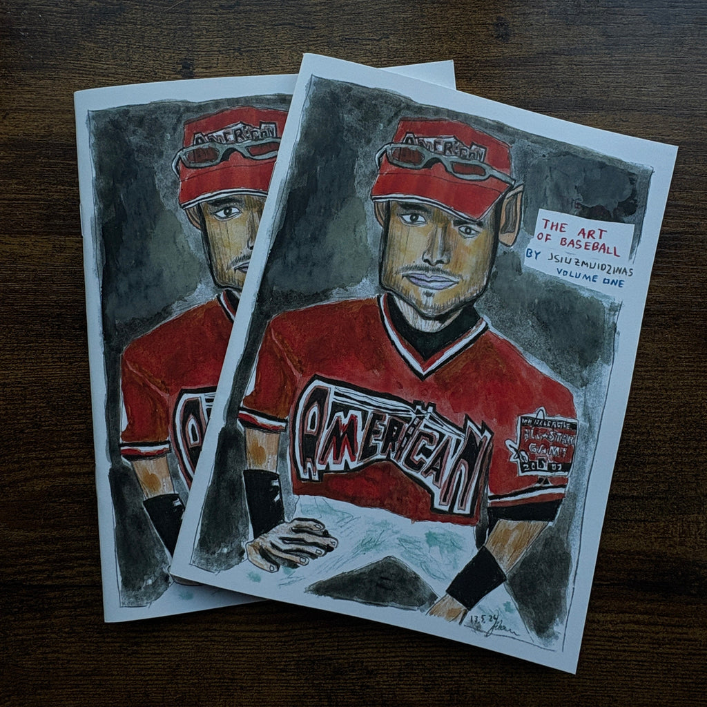 Two baseball cards with a player in a red uniform on a wooden surface