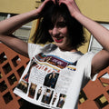 Person wearing a t-shirt with a graphic design in front of a building